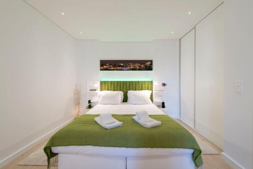 波尔图Heart of D. Pedro Apartments III的卧室配有一张带白色墙壁的大床