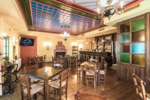 阿诺佩蒂纳Ameliko Zagori的一间带桌椅的餐厅和一间酒吧