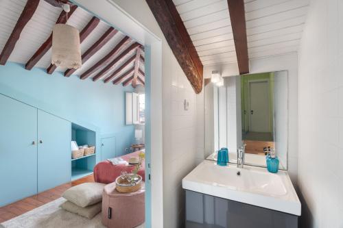 波尔图Own Places Clérigos Apartments的一间带水槽的浴室和一间客厅