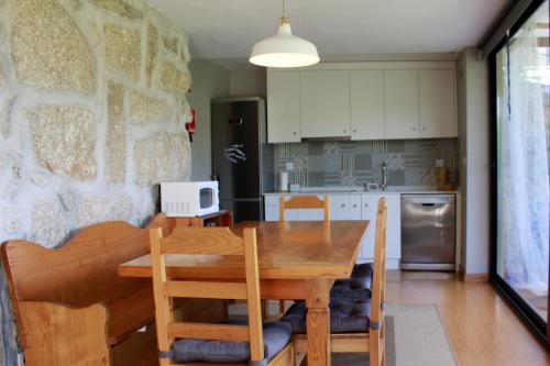 布拉加Quinta Santo António Amares的一间带木桌和椅子的厨房以及一间用餐室