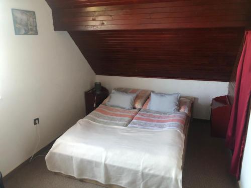欧尔菲Anita Apartmanház的一间小卧室,配有一张木天花板床