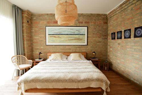 新扎姆基Art Gallery Apartment的一间卧室设有一张大床和砖墙