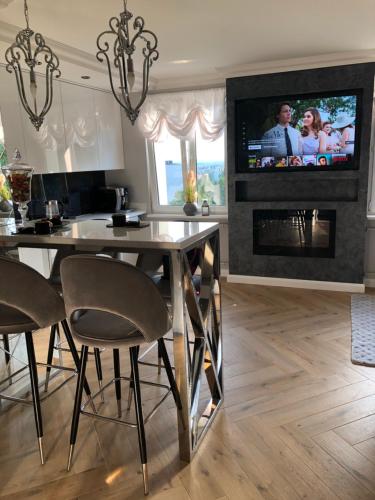 凯尔采Apartament Primavera z sauną的客厅设有餐桌和壁炉上的电视