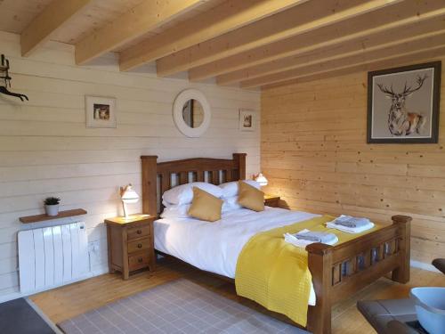 波特里An Traigh Cabin的卧室配有一张床铺,位于带木墙的房间内