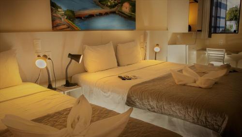 累西腓Pousada Elo Inn的酒店客房设有两张床和两盏灯。