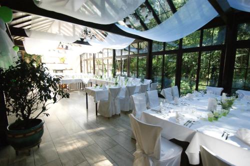 波恩瓦尔德咖啡-餐厅-酒店的大楼内带白色桌椅的用餐室