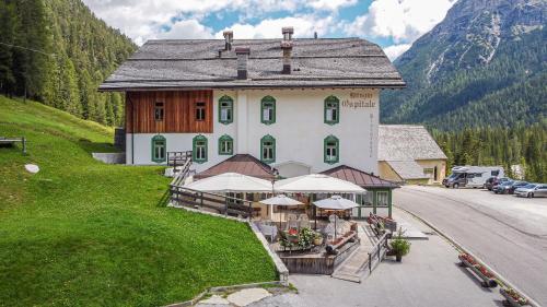 科尔蒂纳丹佩佐Ristorante Rifugio Ospitale的山丘上一座大建筑,毗邻一条公路