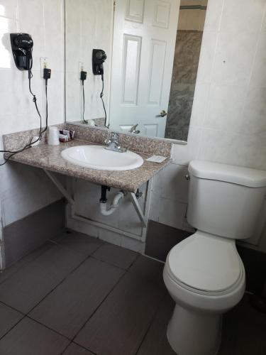 长滩金鹰汽车旅馆的浴室配有白色卫生间和盥洗盆。