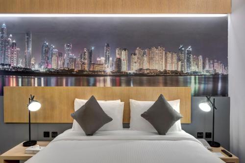 迪拜URBAN Al Khoory Hotel的一间带一张大床的卧室,享有城市天际线