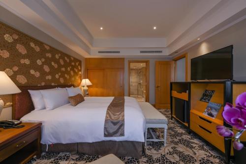 高雄丽尊酒店的配有一张床和一台平面电视的酒店客房