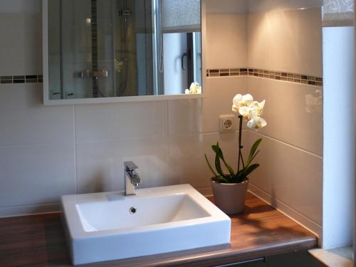 巴特利本施泰因Ferienhaus Villa Bourguet的浴室设有白色水槽和花瓶