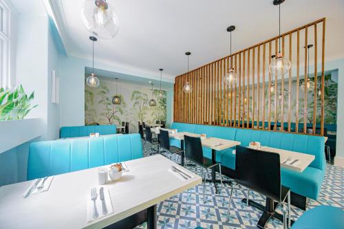 伦敦Mentone Hotel的一间配备有桌子和蓝色椅子的用餐室