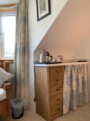 邓迪Dupplin152 bed and breakfast的客房设有木制梳妆台和窗户。