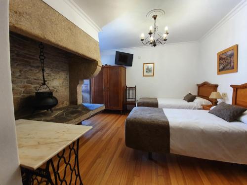 圣地亚哥－德孔波斯特拉吉亚达斯旅馆的酒店客房设有两张床和壁炉