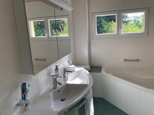 Mont-sur-Rolle威灵托尼亚住宿加早餐旅馆的白色的浴室设有水槽和浴缸。