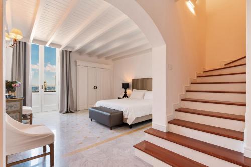 加利波利帕拉泽德可索 - 精品酒店的一间卧室配有一张床,楼梯通往卧室