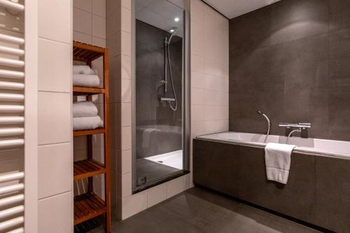 弗洛德罗普鲁尔蒙德沃德普波斯酒店的带浴缸、水槽和淋浴的浴室