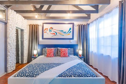 拿骚Parrot Cottage at Viking Hill - Love Beach的一间卧室配有一张带两盏灯的蓝色和白色的床。