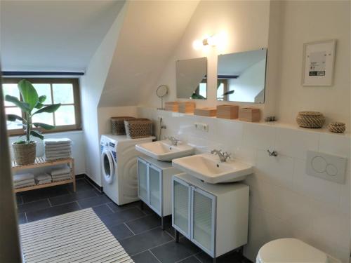 AntdorfFerienwohnung mit Alpenblick的一间带两个盥洗盆和洗衣机的浴室