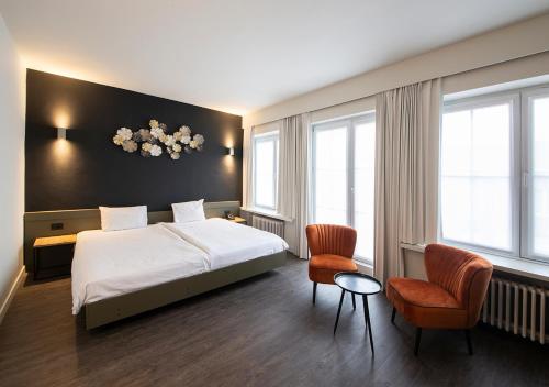 韦弗尔海姆可提纳酒店的酒店客房,配有一张床和两把椅子