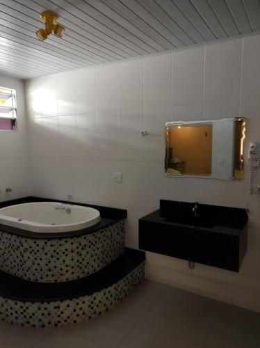 圣若泽杜斯坎普斯Motel Paradise (Adults only)的带浴缸、水槽和镜子的浴室