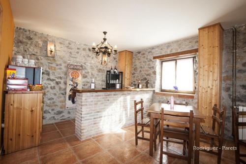 MarEl Pradón的厨房设有砖砌壁炉、桌子和椅子