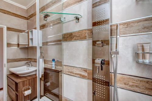 约翰内斯堡Upmarket Ultra Modern Sandton Apartment的带淋浴和盥洗盆的浴室