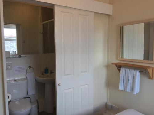 普里茅斯Barbican Reach Guest House的白色的浴室设有卫生间和水槽。