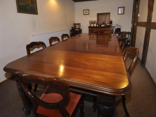 塞文河畔厄普顿Bluebell Farm的一张大木桌,四周摆放着椅子