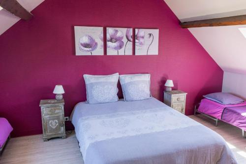 埃特勒塔la belle vue le diamant des yeux mer et golf front mer的一间卧室设有粉红色的墙壁、一张床和两张桌子