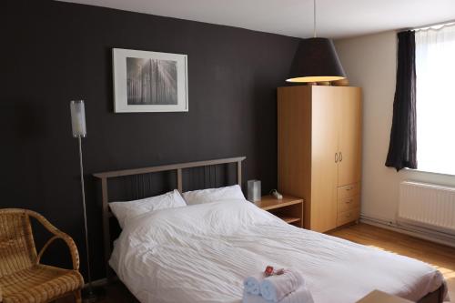 布鲁塞尔布鲁塞尔住宿加早餐酒店的卧室配有白色的床和椅子