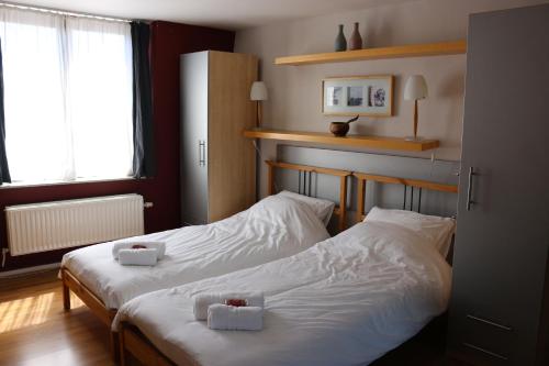 布鲁塞尔布鲁塞尔住宿加早餐酒店的配有白色床单的酒店客房内的两张床