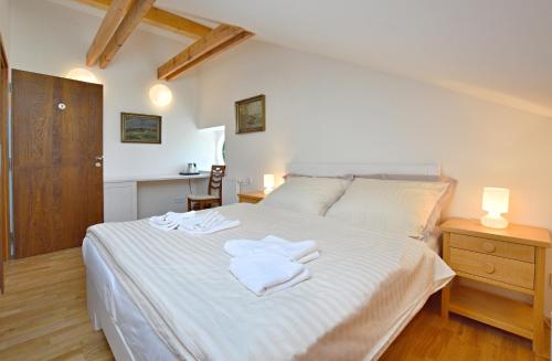 热夫尼采Pivovar Řevnice的卧室配有白色的床和2条毛巾