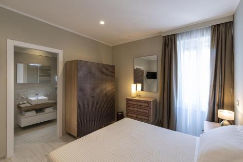 斯波莱托Gli Archi Spoleto的一间卧室配有一张床,浴室设有水槽