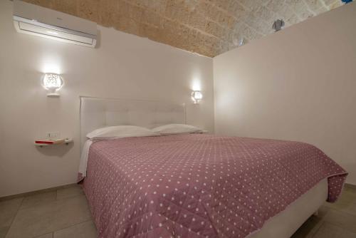 滨海波利尼亚诺Nivis Avis的一间卧室配有一张带紫色棉被的床