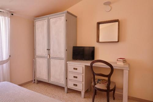 阿西西CORE MIO的一间卧室配有一张桌子、一台电视和一个橱柜