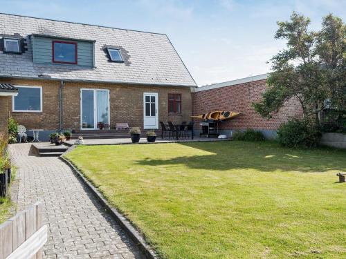 埃斯比约4 person holiday home in Esbjerg V的前面有草坪的砖房