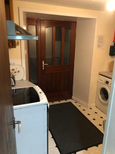 ScallowayCosy holiday home, Scalloway, Shetland.的隔壁的厨房配有洗衣机和烘干机