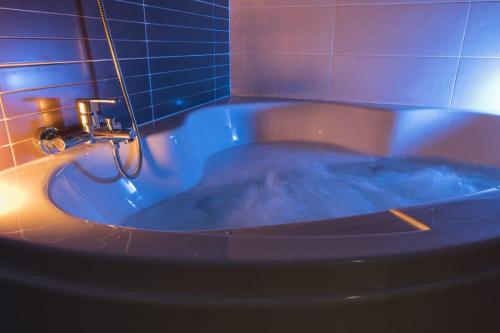 庞特维德拉Albergue GBC Hostel的浴室设有装满蓝色水的浴缸。