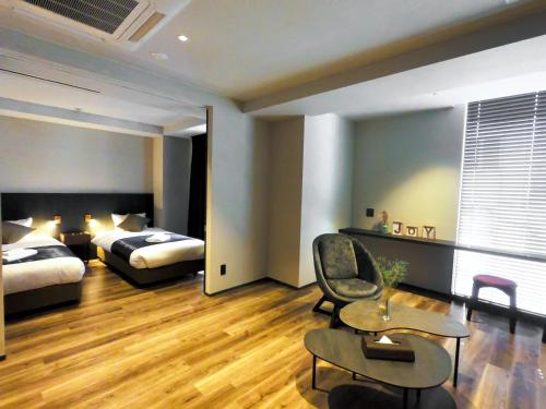大阪Hotel S-Presso South的酒店客房,配有两张床和椅子