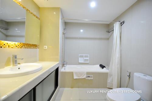 雅加达Kasira Residence的一间带水槽、卫生间和淋浴的浴室