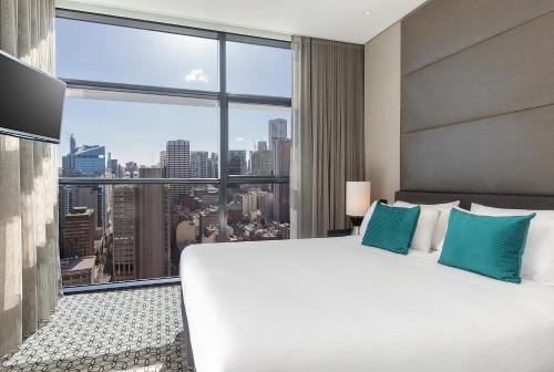 悉尼悉尼辉盛阁国际公寓的卧室设有一张白色大床和大窗户