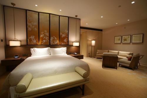 上海上海衡山路十二号华邑酒店的一间带大床的卧室和一间客厅