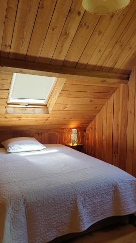 萨尔拉拉卡内达Domaine de la Queyrie的木制客房内的一间卧室,配有一张床