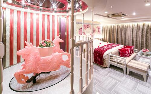 名古屋丽晶酒店（仅限成人）的卧室配有粉红色的床和婴儿床。