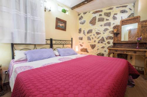 伊科德洛斯维诺斯Casa Amparo的一间卧室配有一张带红色毯子的大床