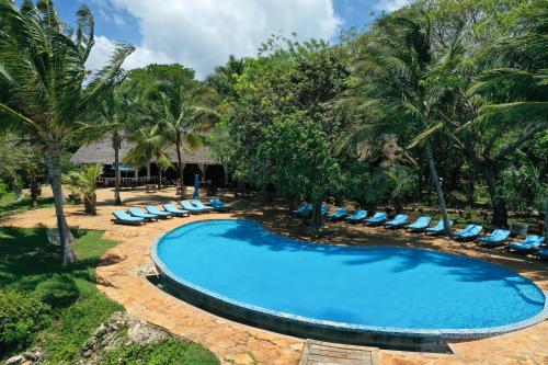 Fumba丰巴海滩旅馆的一座带躺椅和棕榈树的空游泳池