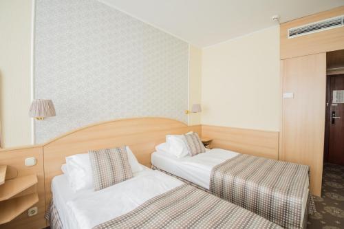 布达佩斯猎户座城堡花园酒店的一间酒店客房,房间内设有两张床