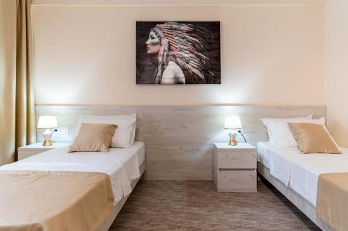波德戈里察Hotel RIO VERDE的配有两盏灯的房间的两张床