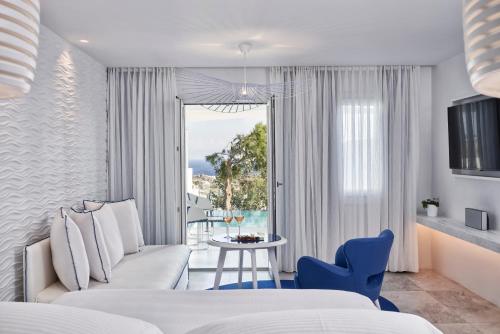 普拉迪斯亚罗斯麦柯尼亚安大使罗莱夏朵酒店的一间带沙发、桌子和窗户的卧室